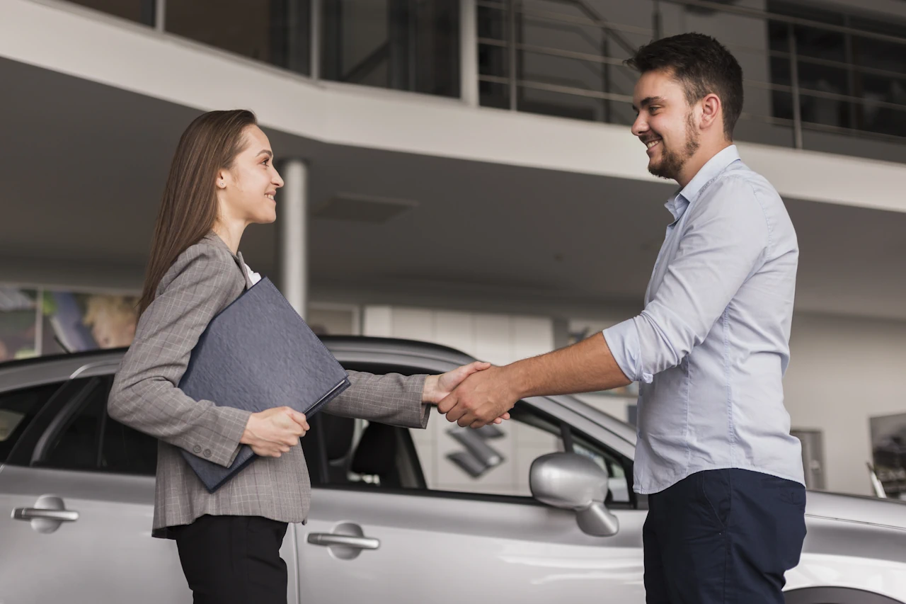 lateral-view-young-man-shaking-hands-with-car-dealer