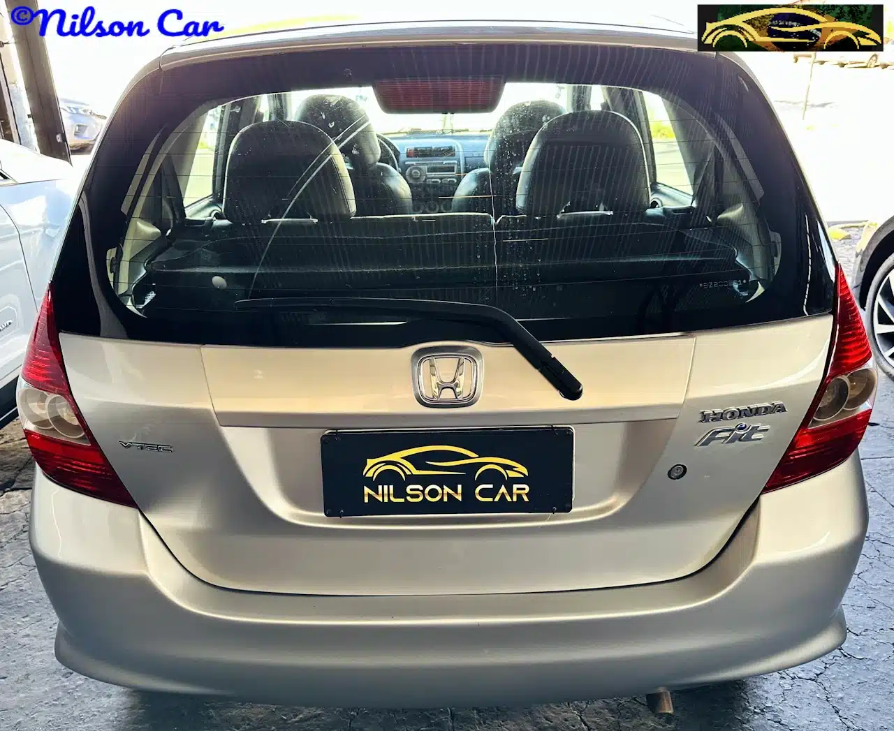 2008 Honda Fit EX 15 Prata - back-WM - Nilson Car Rear view of a silver Honda Fit with Nilson Car license plate and dealership logos visible on the plate and image corners