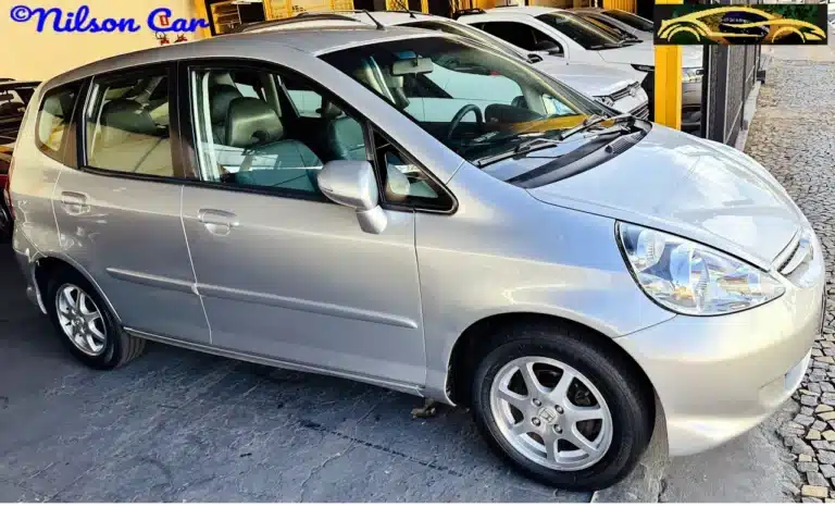2008 Honda Fit EX 15 Prata - side-WM - Nilson Car Silver Honda minivan parked at a dealership with other cars in the background, side view visible.