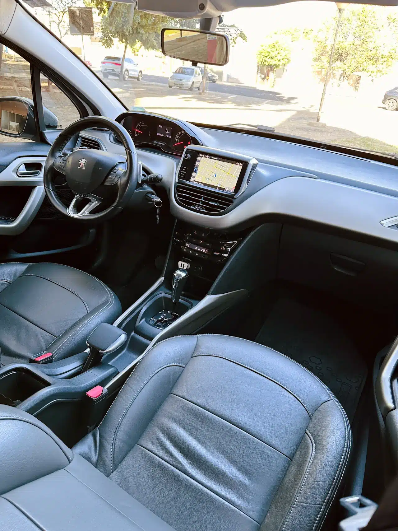 2016 PEUGEOT 2008 16 ALLURE BRANCA - dash2 - Nilson Car Interior of a car showing the steering wheel, digital instruments, and a central touchscreen map display on the dashboard.