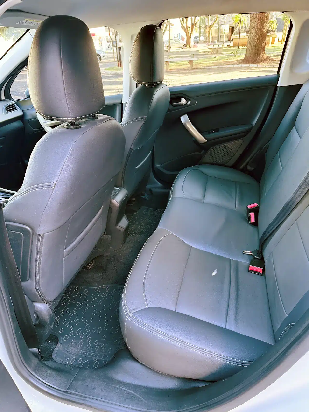 2016 PEUGEOT 2008 16 ALLURE BRANCA - rear_seats - Nilson Car Rear passenger area of a car with gray leather seats, two headrests, and visible seat belts on the bench seat.