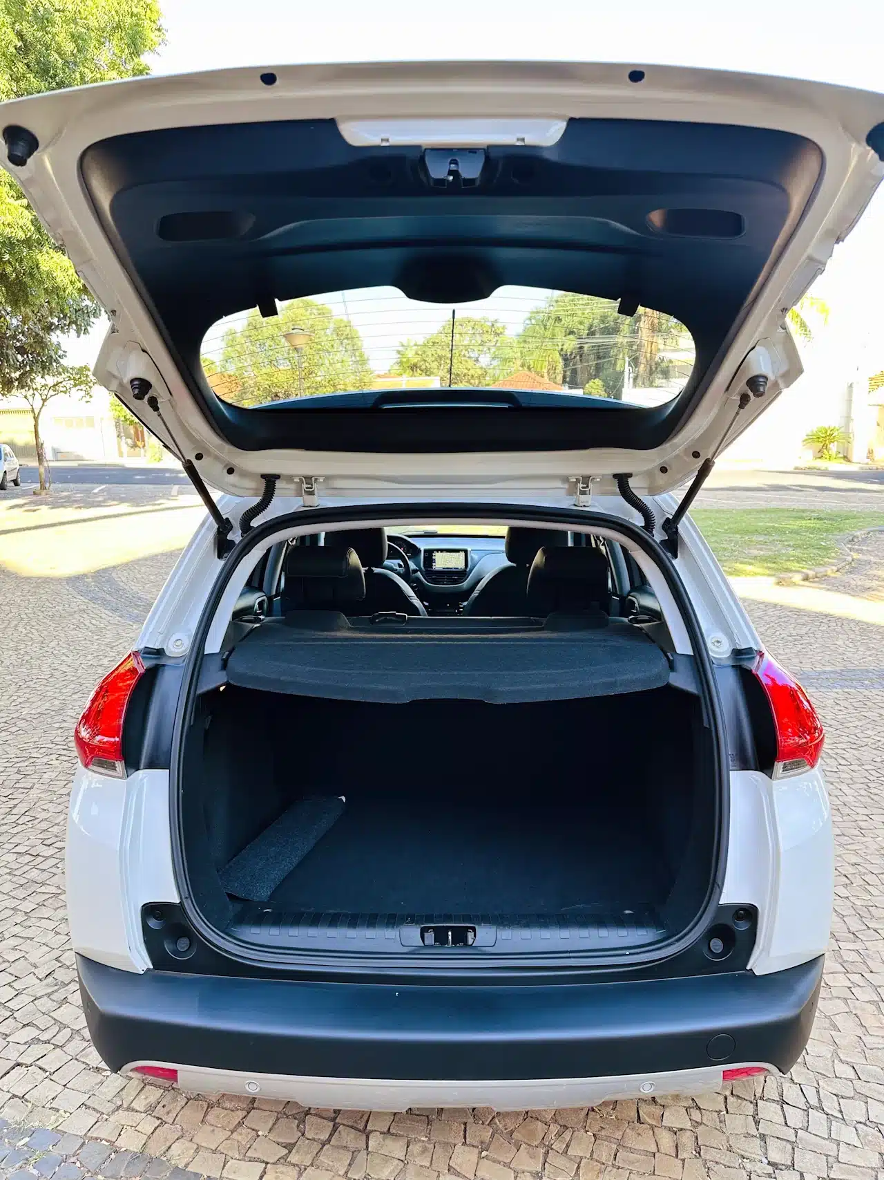 2016 PEUGEOT 2008 16 ALLURE BRANCA - trunk - Nilson Car Open rear hatch of a white SUV showing empty cargo area and folded rear seats visible inside